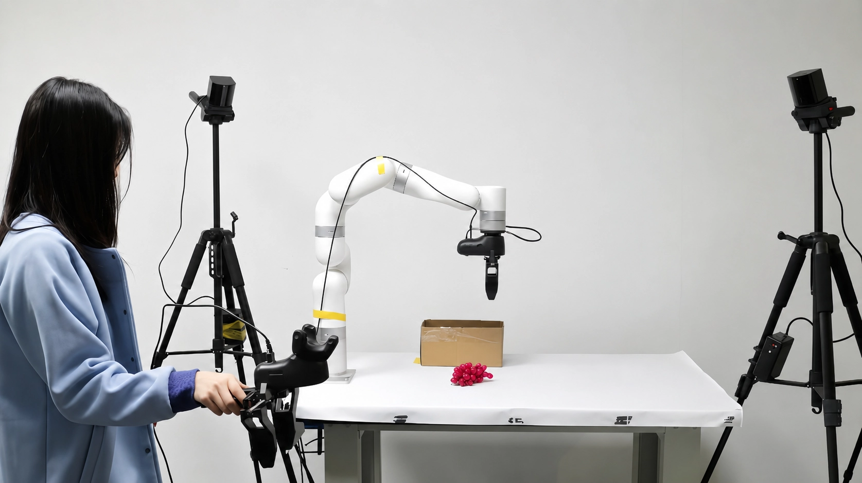 An operator guides an xArm using a handheld teleoperation controller