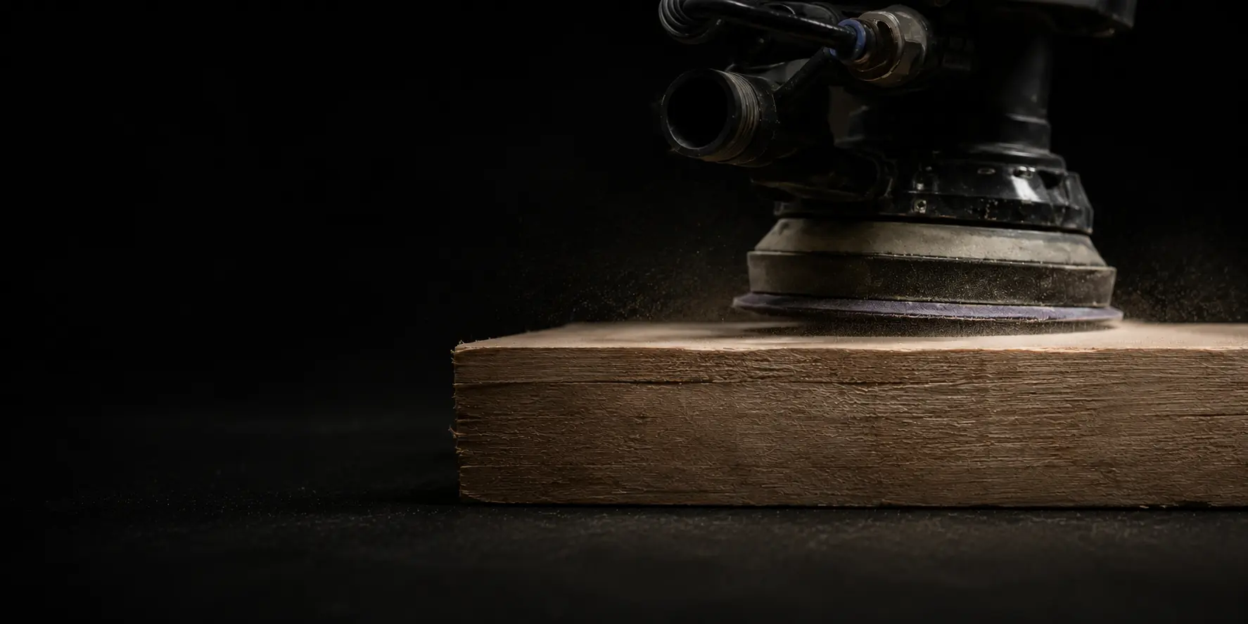 Sander working across the face of a wooden board