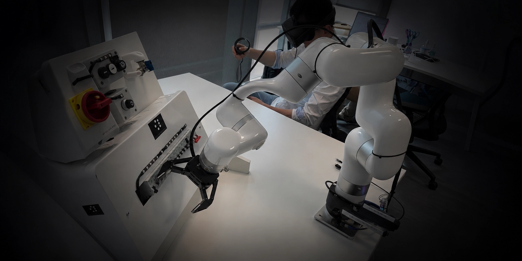 Operator in a VR headset teleoperating two UFACTORY cobots to work on an electrical control panel