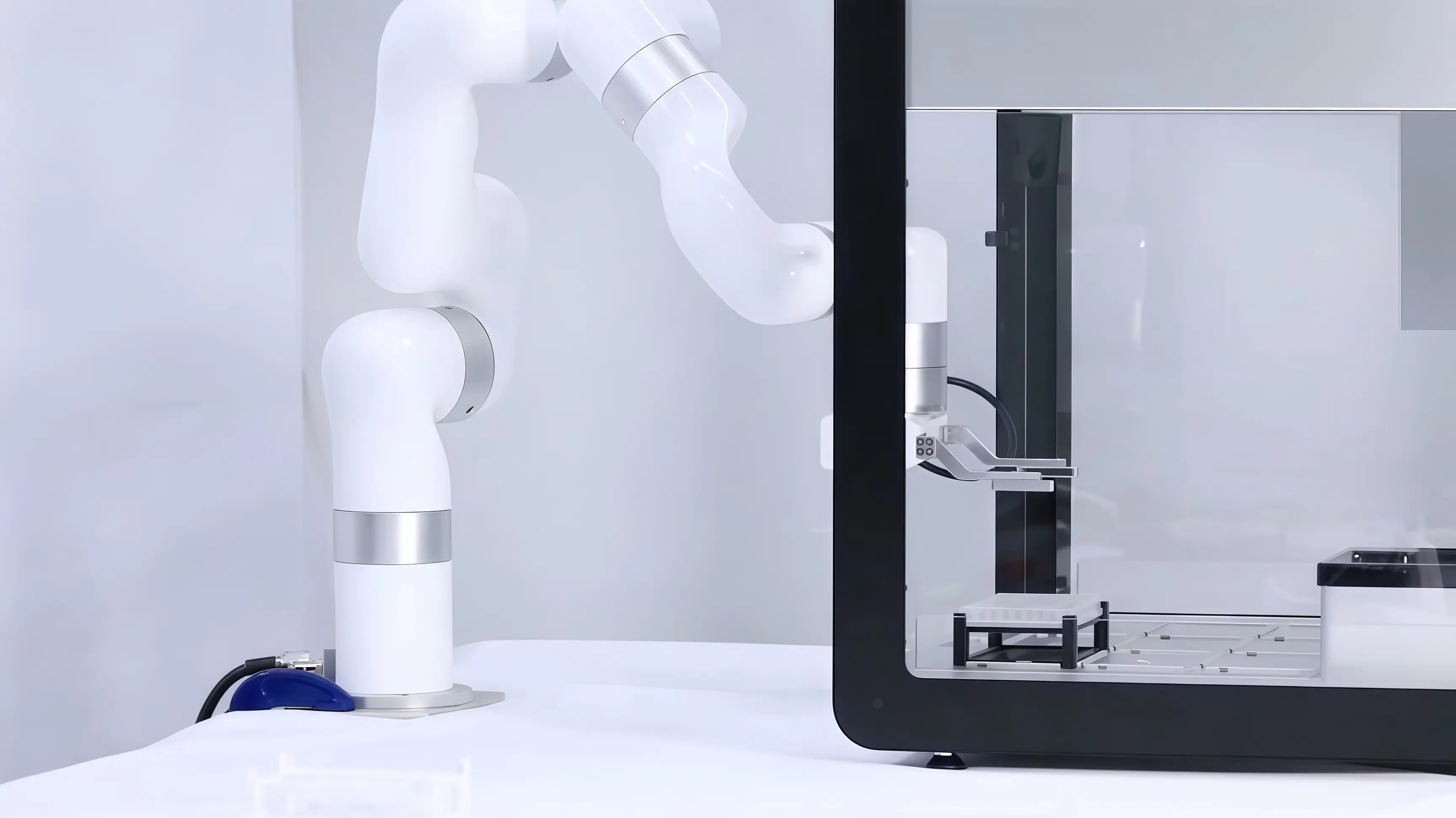 xArm cobot reaches into an enclosed laboratory workstation during an automation test.