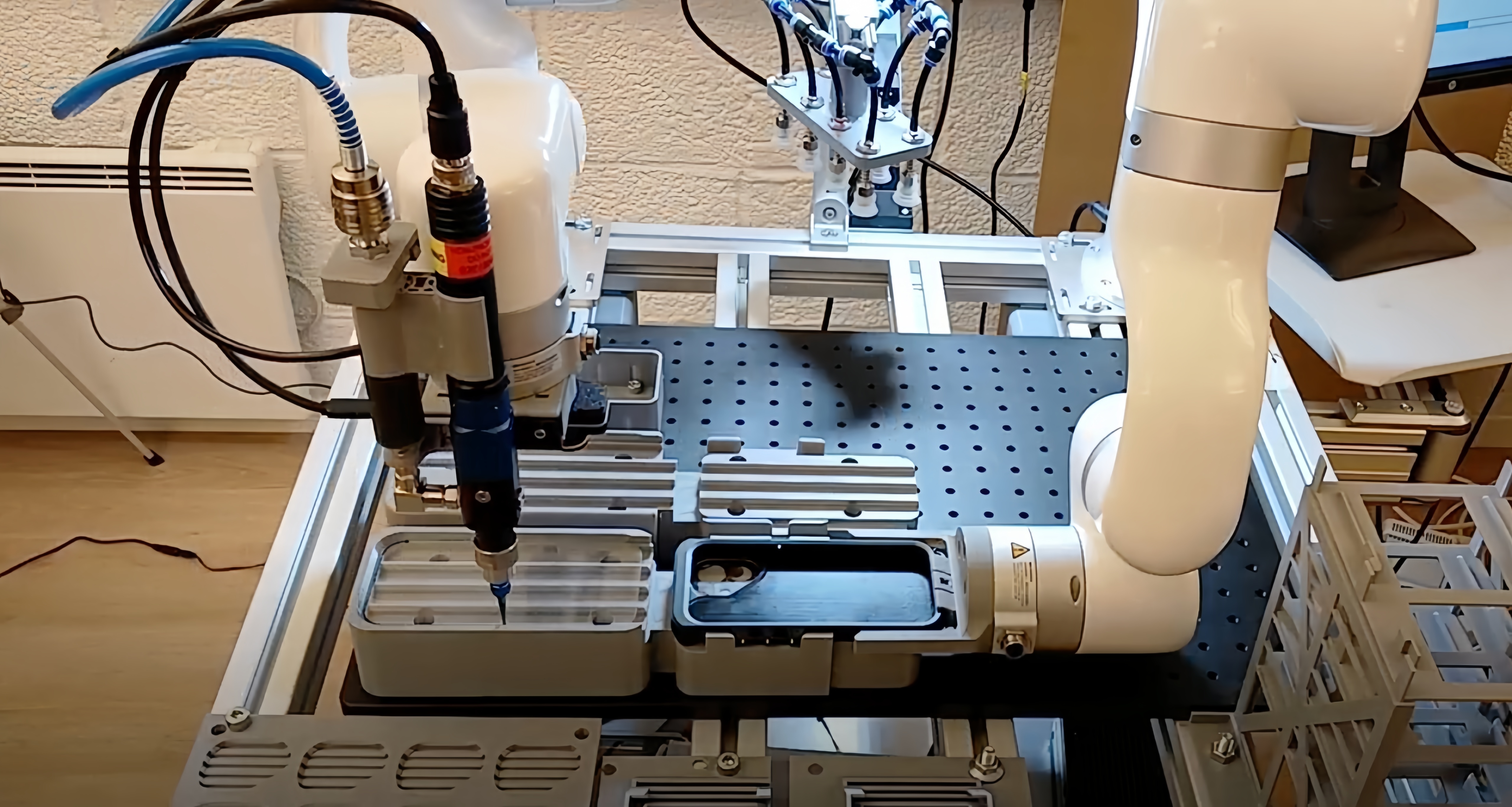 UFACTORY cobot dispensing adhesive along the edge of a phone enclosure held in a fixture