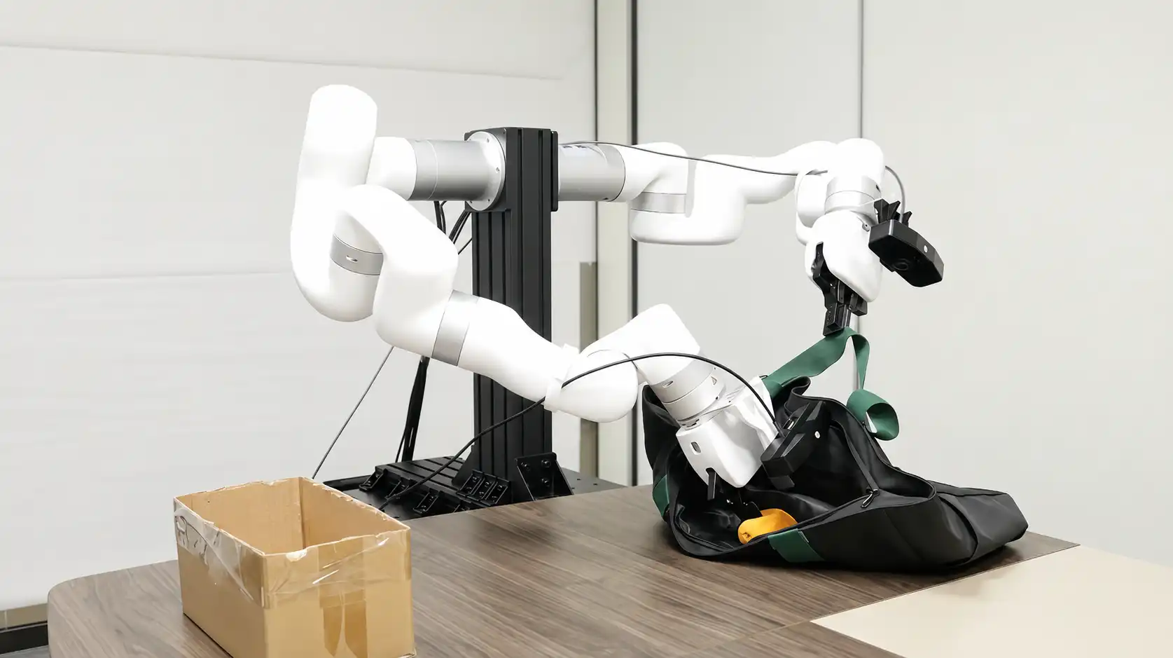 Two xArm robotic arms coordinate to manipulate a bag during a bimanual imitation-learning task