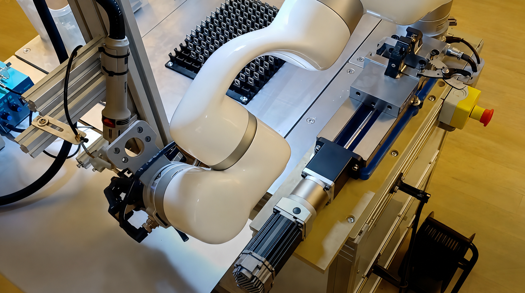 xArm cobot handles components beside fixtures and part trays in an automated assembly workstation