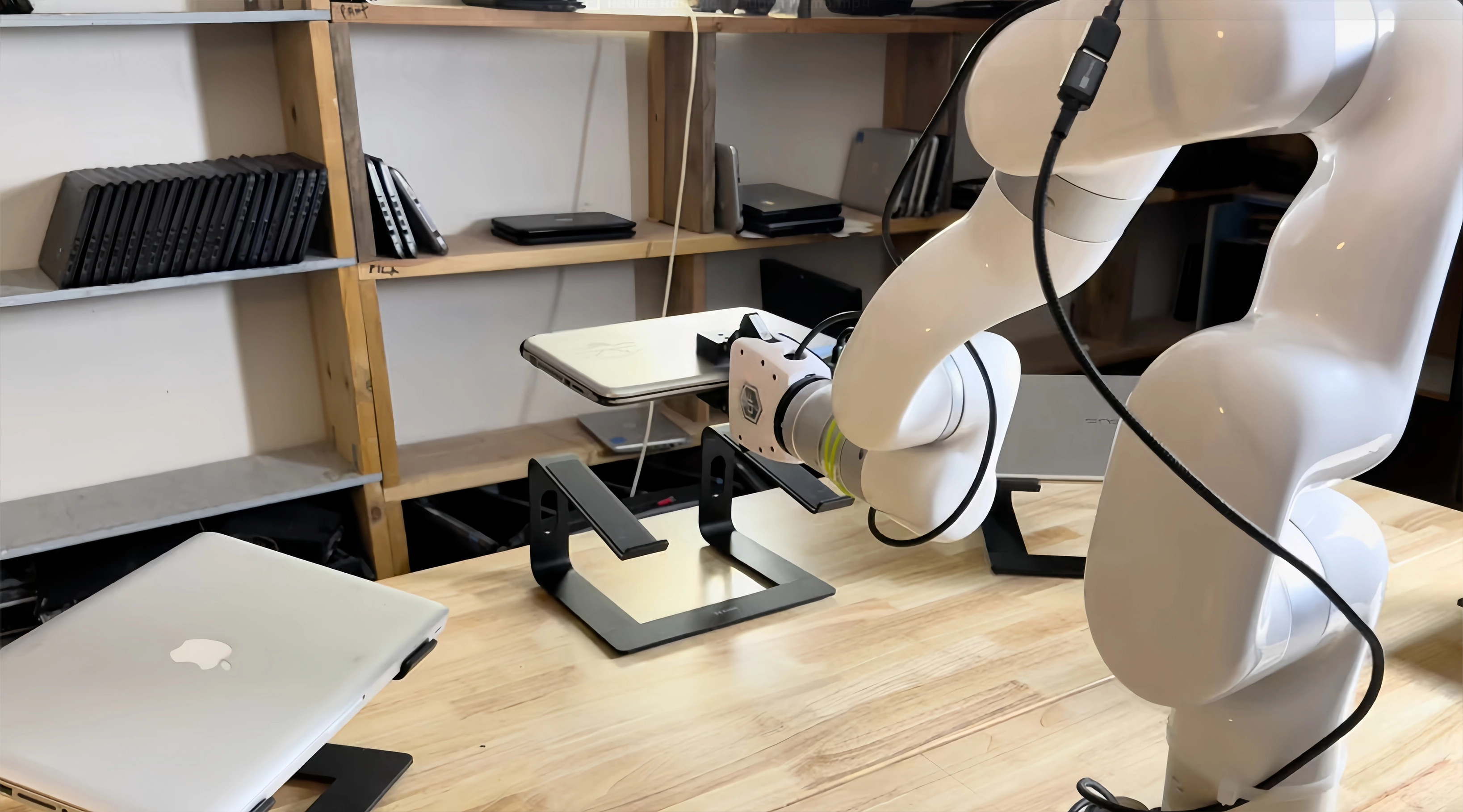 UFACTORY cobot holding a laptop above a stand during refurbished computer inspection