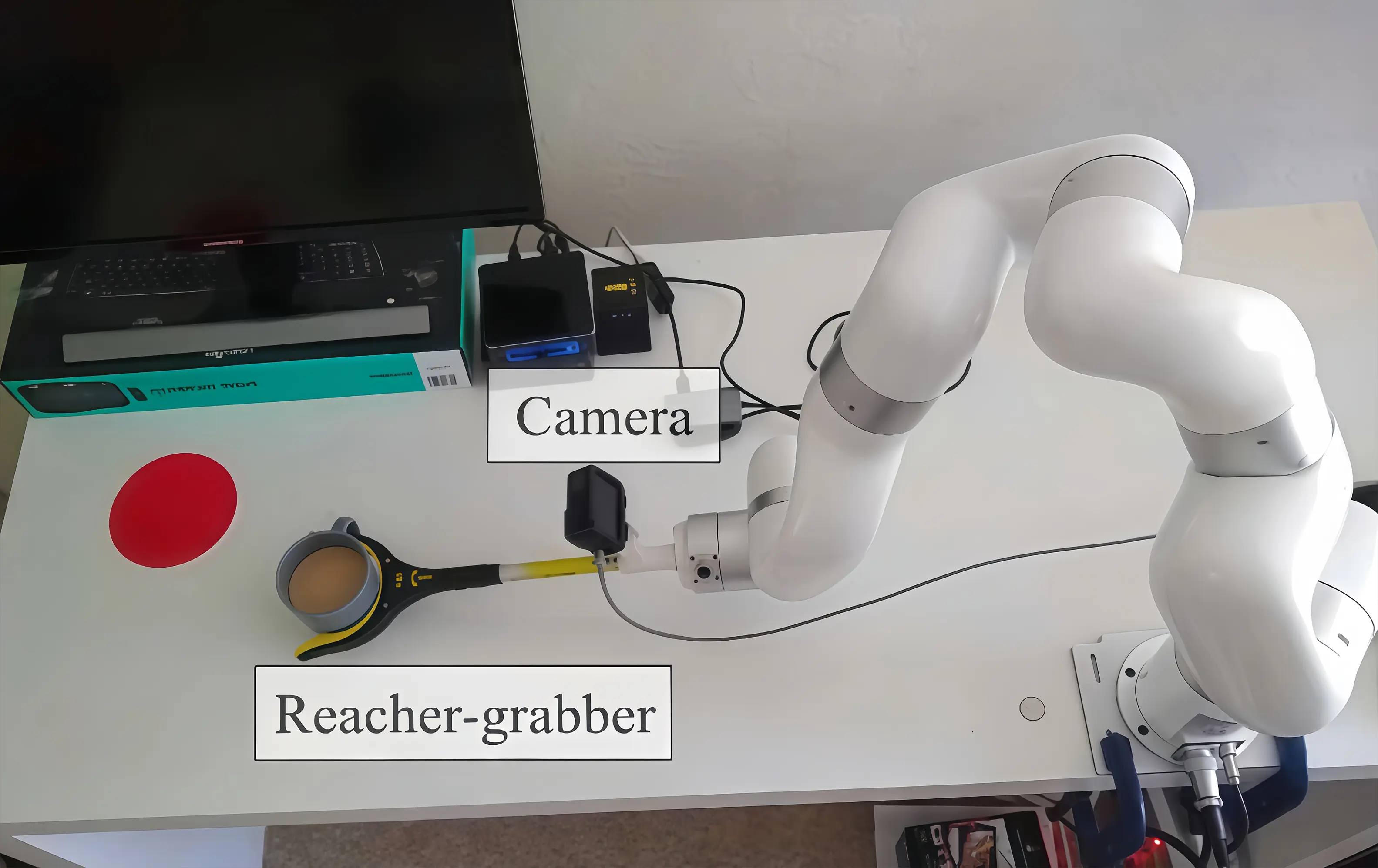 xArm 7 with a camera-mounted reacher-grabber moves a cup to the red target area during a tabletop manipulation task