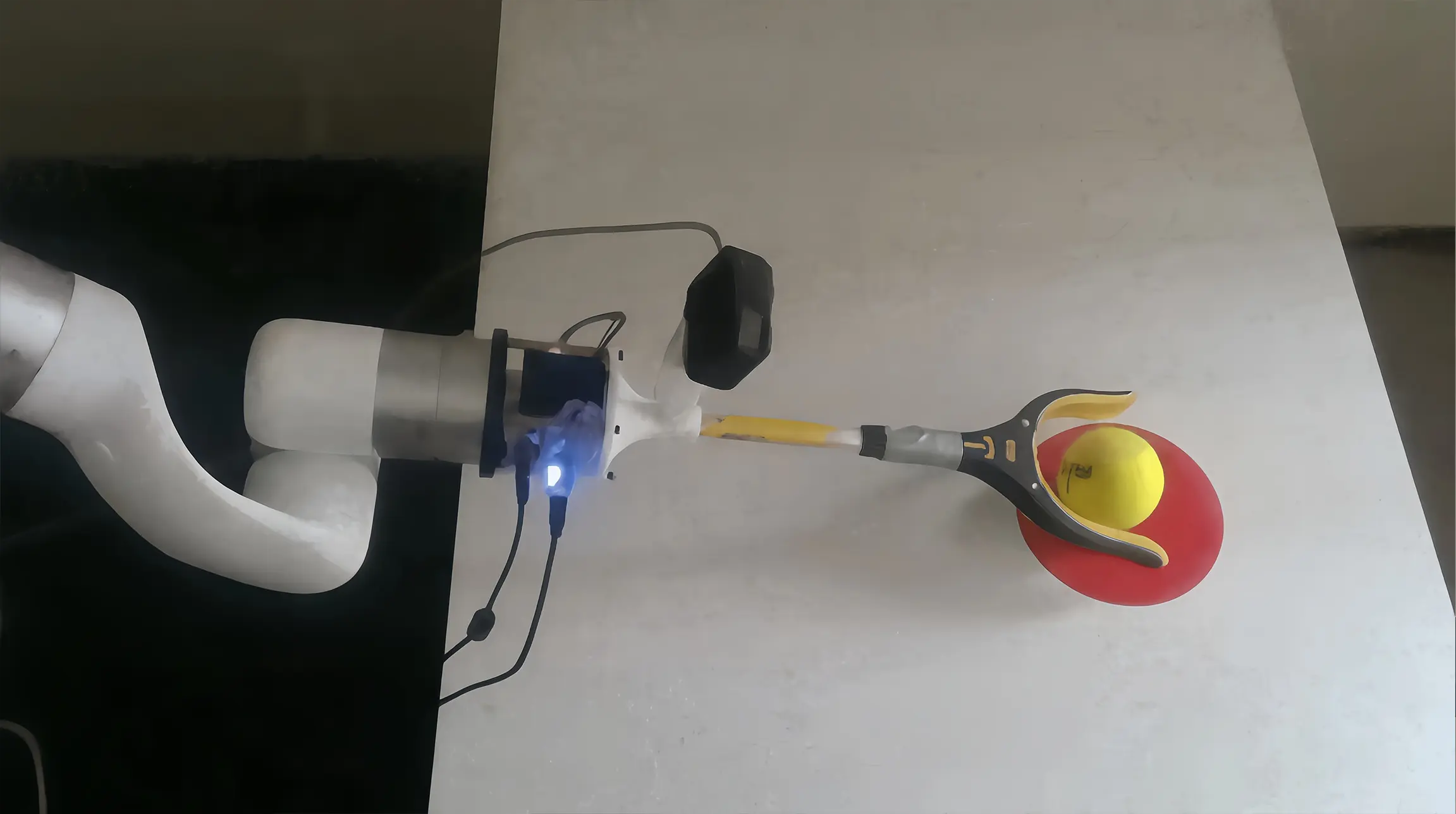 xArm 7 uses a camera-equipped reacher-grabber to move a yellow ball toward a red target during an imitation learning test